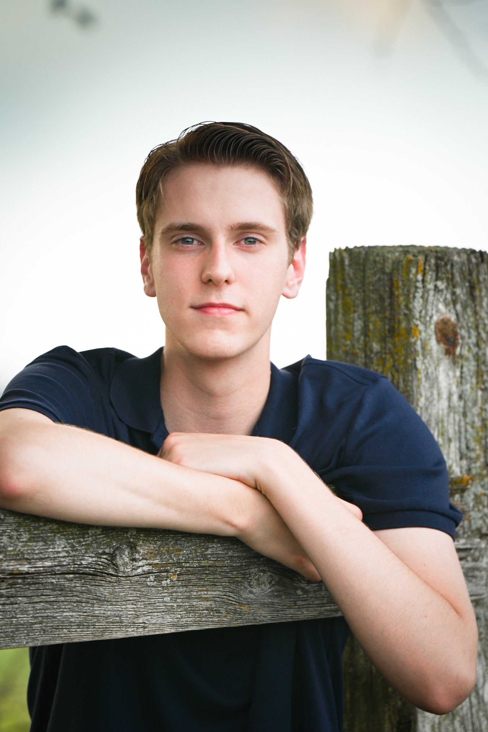 Portrait of Will Egolf leaning on a wooden fence